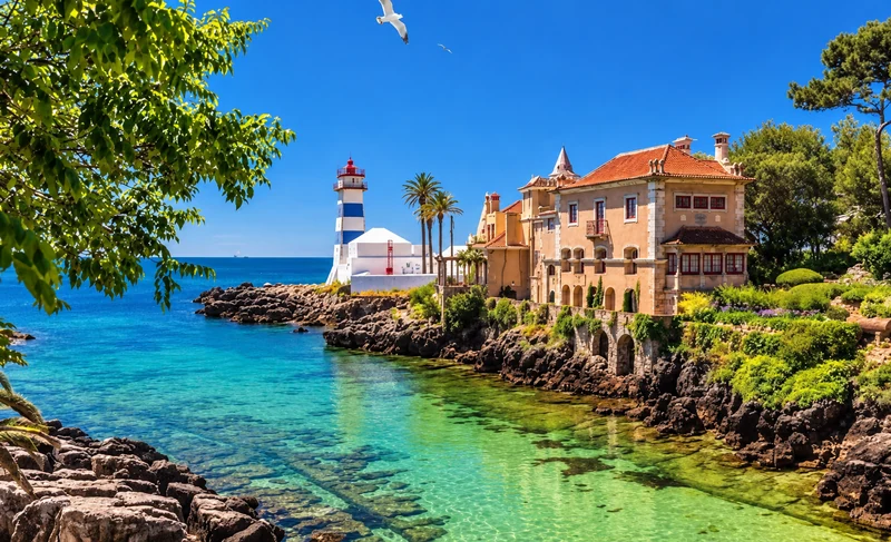 Farol de Santa Marta e edifício histórico junto à água em Cascais